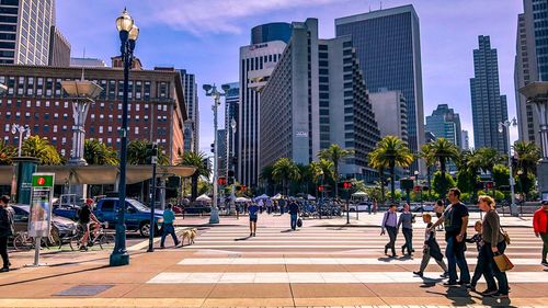 People walking on street amidst buildings in san francisco 