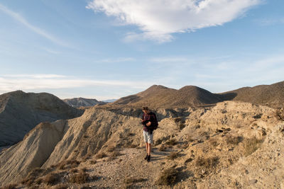 Rear view of man on mountain against sky