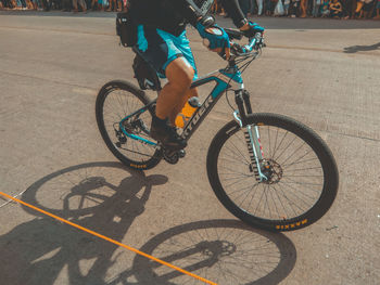 Low section of person riding bicycle on street