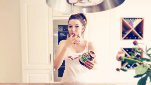 Portrait of young woman standing at home