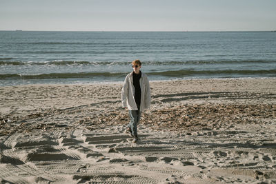 Young man walking on beach