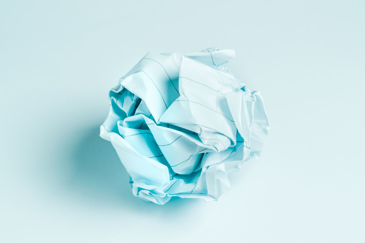 HIGH ANGLE VIEW OF WHITE PAPER AGAINST BLUE BACKGROUND