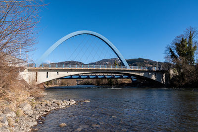 Bridge over river against clear blue sky