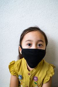 Portrait of cute girl against wall