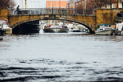 Boats in river with buildings in background