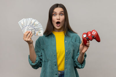 Portrait of smiling young woman holding toy against white background