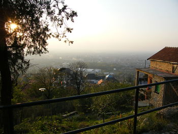 High angle view of trees and buildings against sky during sunset