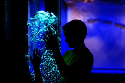 Boy looking jellyfish in tank
