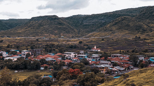 Aerial view of buildings in city against sky