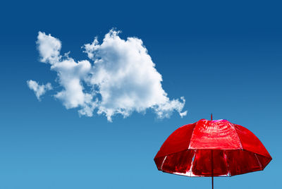 Low angle view of red wall against blue sky