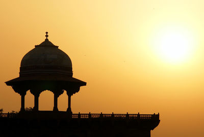 Silhouette temple against sky during sunset