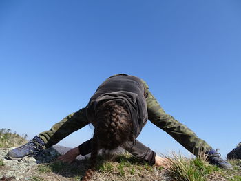 Full length of young man against clear blue sky