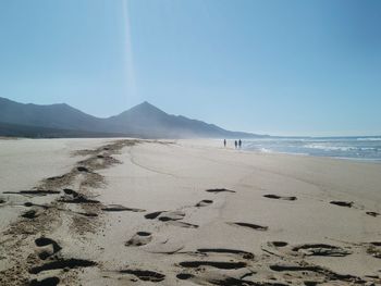 Scenic view of beach against blue sky