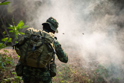Rear view of man against plants
