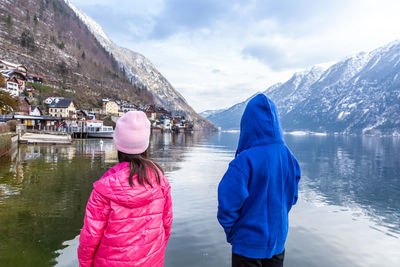 Rear view of women on lake against sky