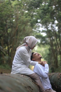 Rear view of couple kissing in forest