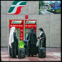 Rear view of women standing on sign board in city