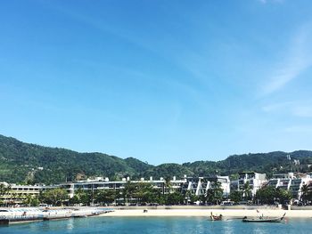 Boats moored on sea against blue sky