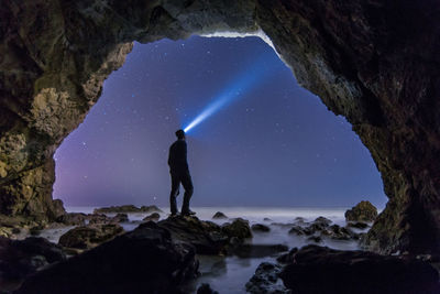 Man in cave at night