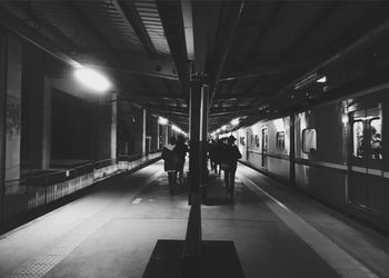 People at illuminated railroad station