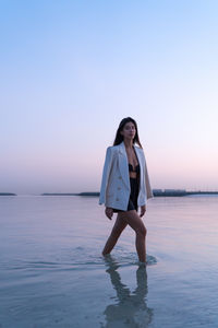 Portrait of a beautiful middle eastern woman walking in the water wearing a jacket