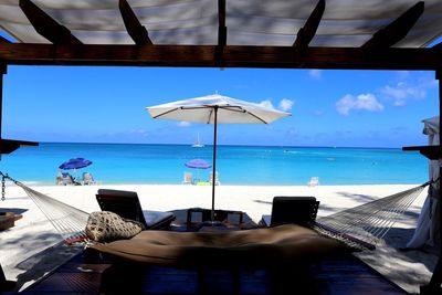 Chairs and tables on beach against sky