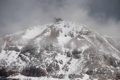 Low angle view of frozen mountain against sky