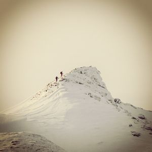 Two people walking on snow covered landscape