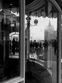 People in city seen through glass window