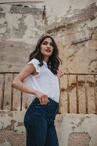 Portrait of woman standing against wall