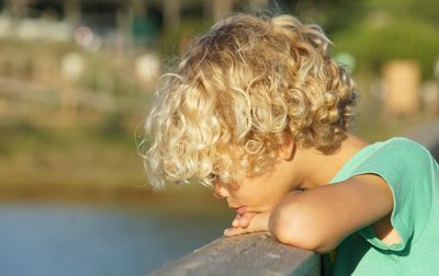 Close-up of thoughtful boy leaning on railing