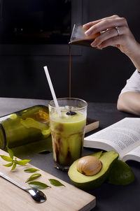 Close-up of hand holding drink on table