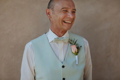 Portrait of smiling man standing against wall