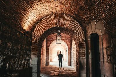 Rear view of man standing in historic building