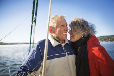 Cheerful senior couple in yacht on sea against clear sky