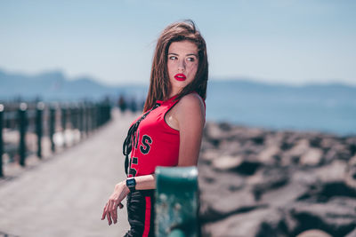 Portrait of woman standing by sea against sky