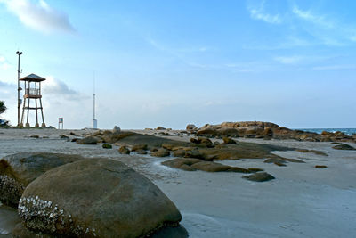 Rocks on beach against sky