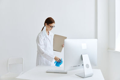 Rear view of woman working on white table