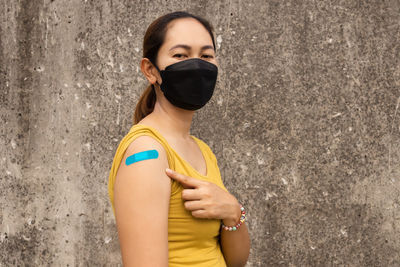 Portrait of woman standing against wall