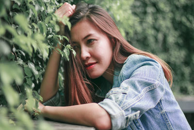 Portrait of young woman with plants