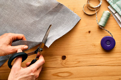 Woman cutting out a pattern paper in linen fabric. seamstress sewing. 