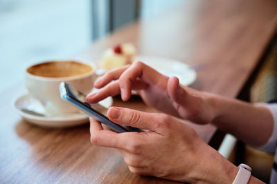 Woman have breakfast at cafe, use smartphone at cafe