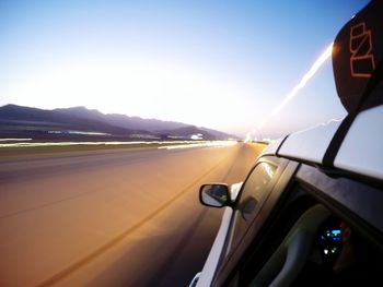 Close-up of car on highway against clear sky