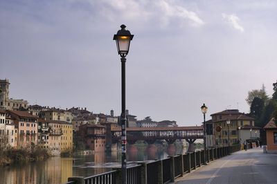 Bridge over river in city against sky