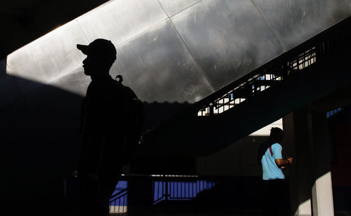 Low angle view of silhouette man standing in corridor