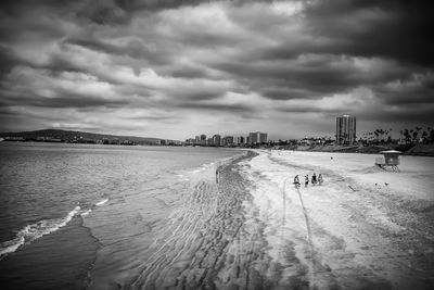 Scenic view of beach against cloudy sky