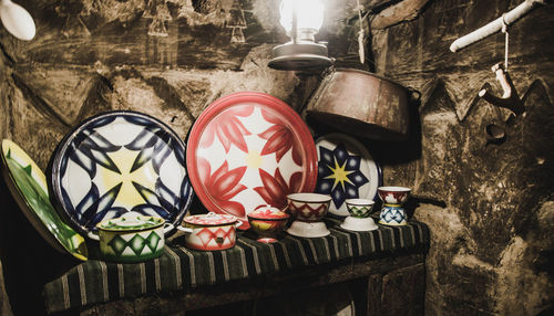Close-up of lantern hanging on table against wall
