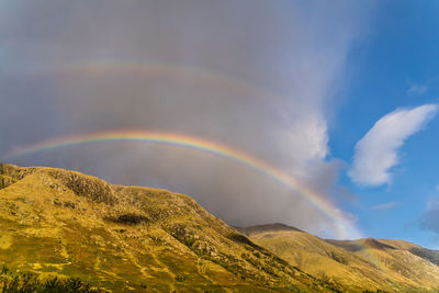 Low angle view of rainbow over mountain against sky