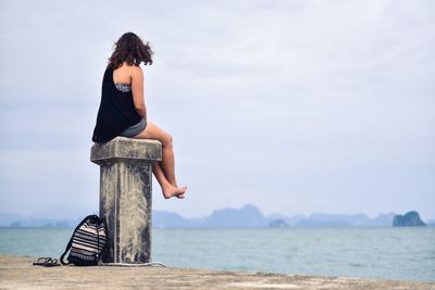 Rear view of woman standing at beach