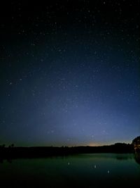 Scenic view of lake against sky at night